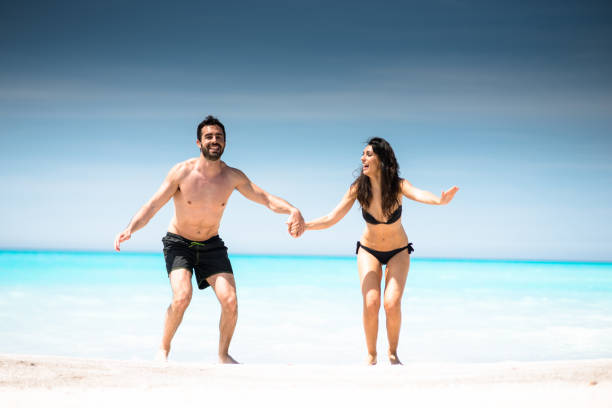 istock happiness couple embracing at seaside with towel 681940200