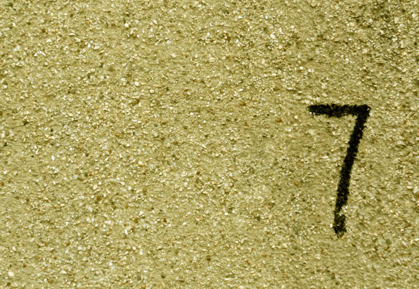 istock Number seven on yellow grunge wall surface. 681942564