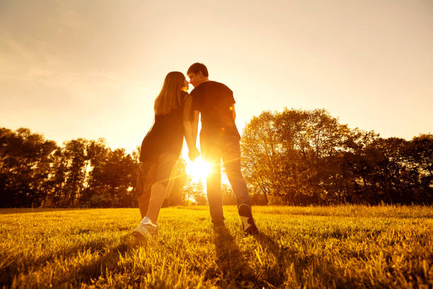 istock Happy couple at sunset in park view from behind 681943106