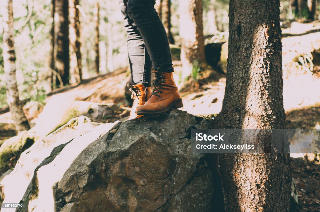 Female legs shod in Hiking boots on the forest background. Travel concept Adult Stock Photo