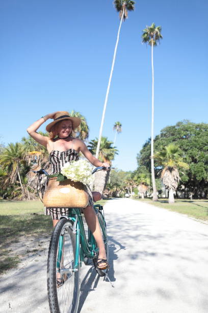 istock Woman riding bicycle in a tropical park. 681958808