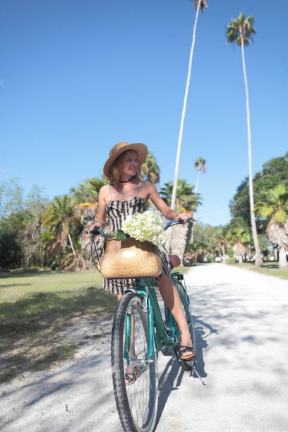 istock Woman riding bicycle in a tropical park. 681958812