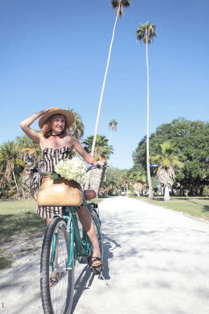 istock Woman riding bicycle in a tropical park. 681959400