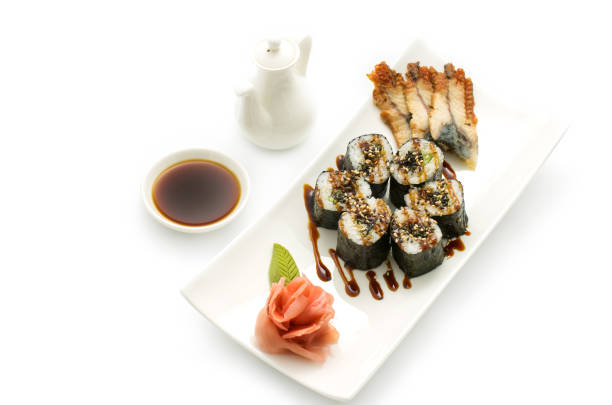 Maki sushi, rolls, nori rice, smoked eel sheets, sesame seeds and teriyaki sauce on a white background
