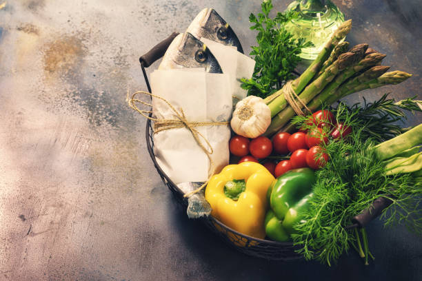Fresh sea bream with various organic vegetables in a basket