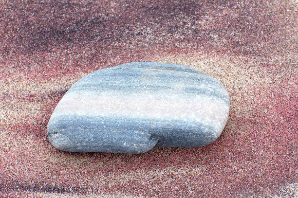 Lonely stone in colorful sand stock photo