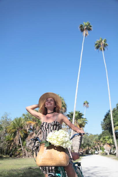 istock Woman riding bicycle in a tropical park. 681990268