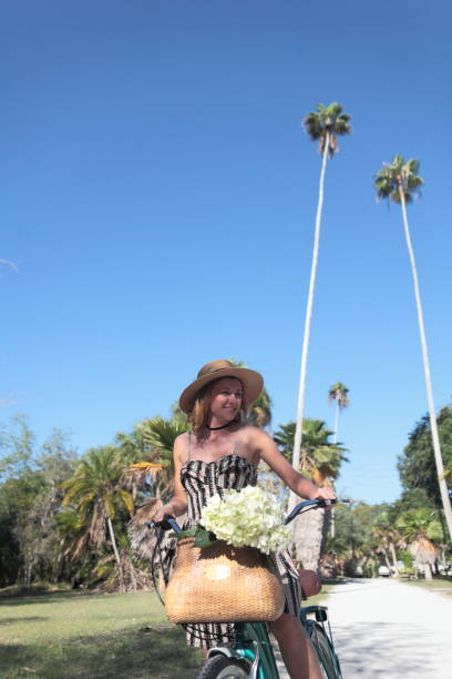 istock Woman riding bicycle in a tropical park. 681990594