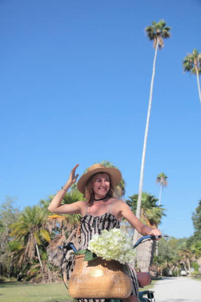 istock Woman riding bicycle in a tropical park. 681990658