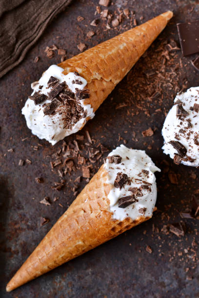 istock Vanilla ice cream cone with chocolate on an old grunge background 681993100