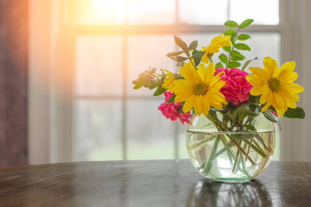 istock Spring flowers on table in vase with dark greys and blacks with open window fresh concept and copyspace. 681997364