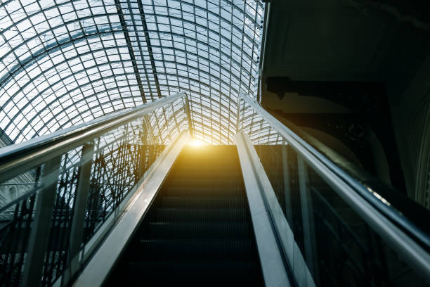 escalator moving up at indoors in building with transparent roof - escalator shopping mall shopping transparent imagens e fotografias de stock