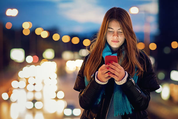istock Young girl is texting on the bridge at night 682005842