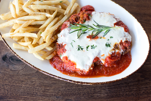 Chicken parmigiana with fresh rosemary and french fries