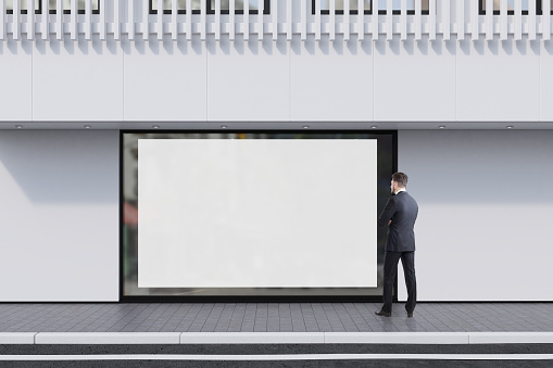 Man looking at a shop window with a large horizontal poster and a white balcony on the second floor. Concept of promotion. 3d rendering, mock up