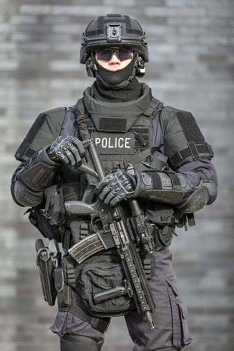 Oficial de policía SWAT contra pared de ladrillos photo