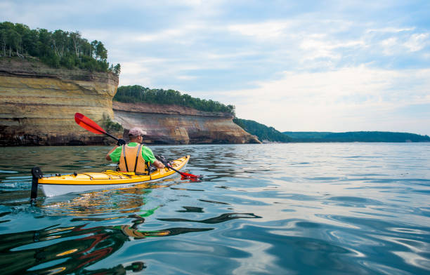kayaker paddling along the cliffs of the Pictured Rocks National Lakeshore in Michigan’s Upper Peninsula, Michigan