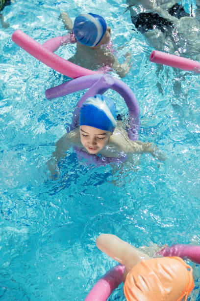 istock happy children kids group at swimming pool class learning to swim 682031600