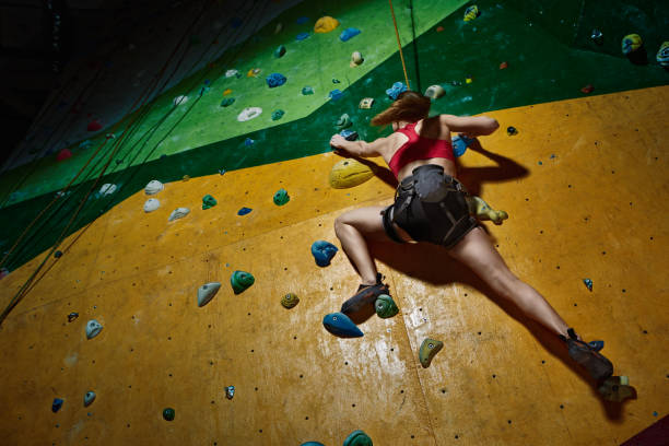 istock Female climber purposeful climbs up the indoor climbing wall 682032014