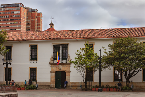 Bogota, Colombia - July 20, 2016: The main entrance to the Universidad del Rosario in historic La Candelaria District of the capital city of Bogota in the South American country of Colombia. It is Veinte de Julio or 20th July and National Day in Colombia which is a holiday; there are therefore not the usual number of people who would normally be seen on the plaza in front of the University. Established in 1653 it is the third oldest university in the country.  Photo shot on an overcast afternoon; horizontal format. Copy space.