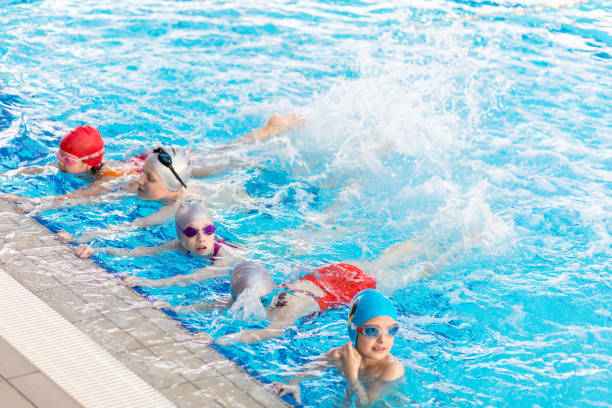 istock happy children kids group at swimming pool class learning to swim 682036092