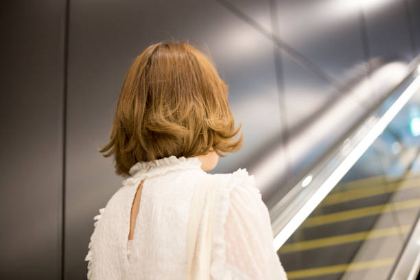 istock Cute woman riding escalator 682046086