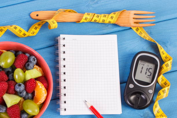 istock Fruit salad, glucose meter, centimeter and notepad for writing notes, diabetes, healthy lifestyle and nutrition concept 682050470