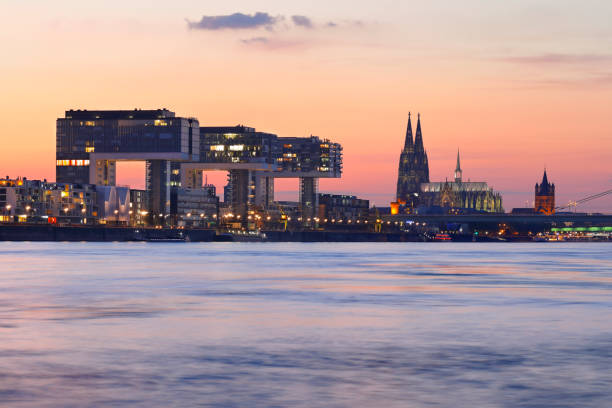 Skyline of Cologne Cathedral and the Crane Buildings (Kranhäuser) at sunset, Cologne, Germany