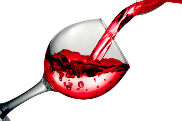 istock Red dry wine pours into a wineglass on a white background 682100196