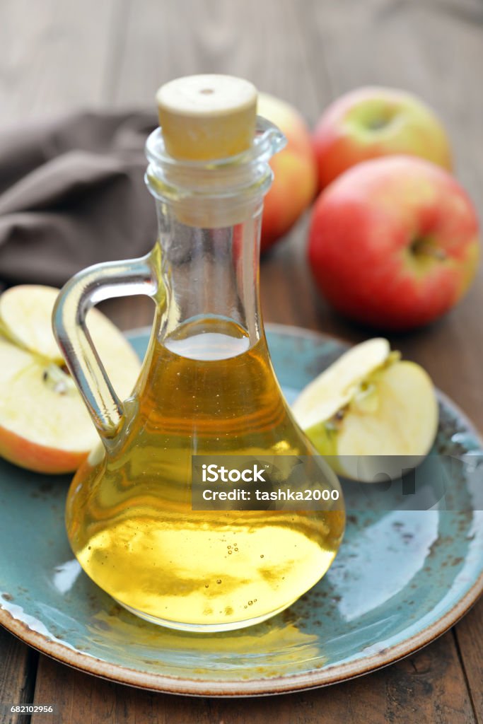 Apple cider vinegar Apple cider vinegar in glass bottle and  fresh apples on wooden background Apple - Fruit Stock Photo