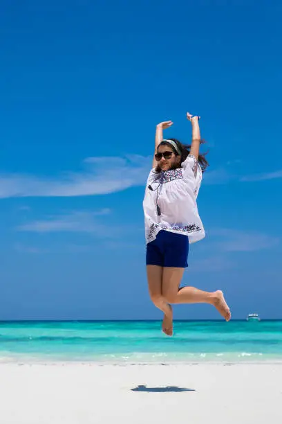 Photo of Asia woman jumping on tropical beach and white sand beach