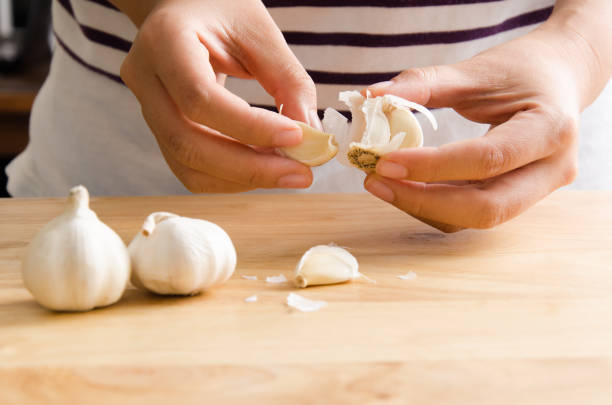 frau knoblauch von hand peeling - schälen essen zubereiten stock-fotos und bilder