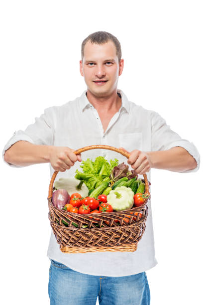 istock Cute young farmer with a harvest of vegetables on a white background 682108070