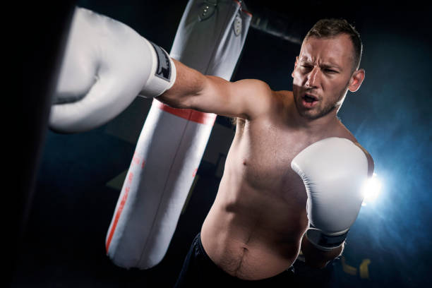 istock Caucasian boxer training and hitting punching bag 682108452