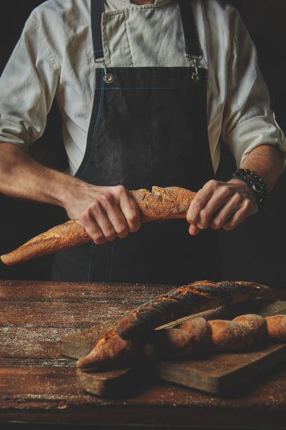 istock Male hands break the baguette 682117338