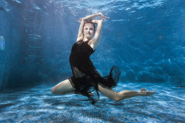 istock Woman dances under the water in the pool. 682125712