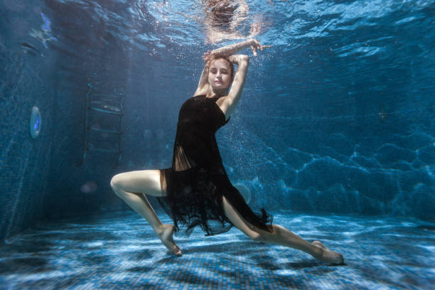 istock At the bottom pool, a woman dances under water. 682125768