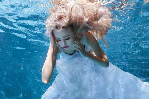 istock Woman in white dress under water pool. 682125892