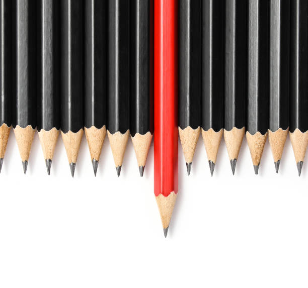 istock Red pencil standing out from identical black fellows. 682126248