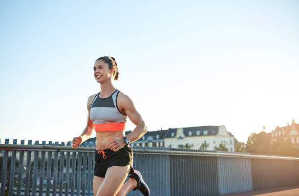 istock Confident woman jogging along bridge 682130120