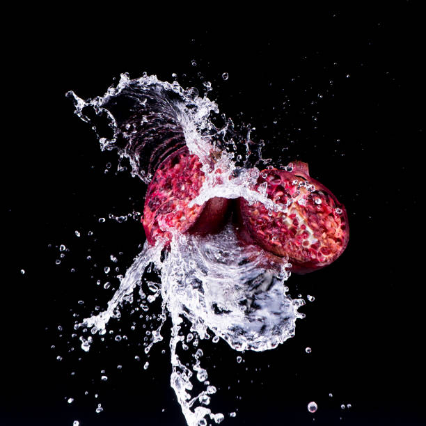 pomegranate in water splash on black backround