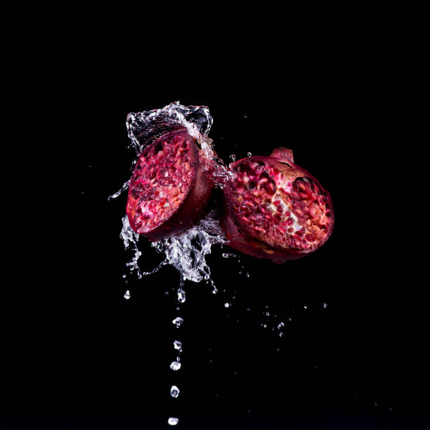 pomegranate in water splash on black backround