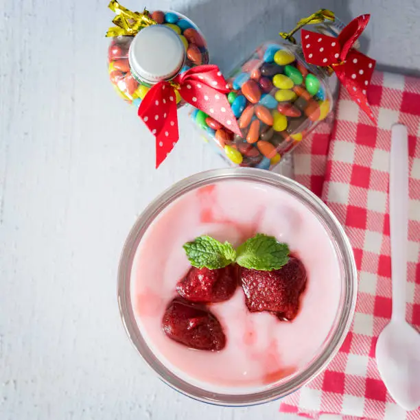 strawberry yogurt with strawberry  on wooden. strawberry yoghurt. pink yogurt. strawberry in strawberry yogurt. heart in yogurt. heart. valentine 's day.