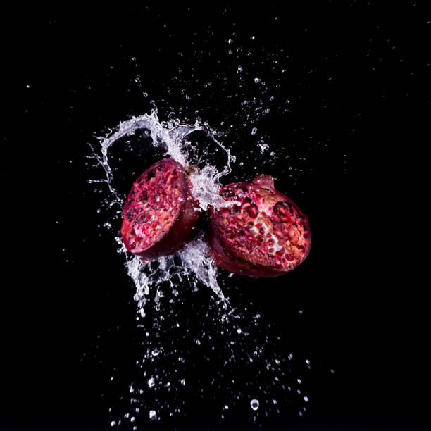 pomegranate in water splash on black backround