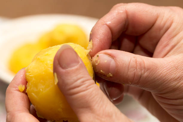 istock Woman cleaning potatoes with her hands 682144752