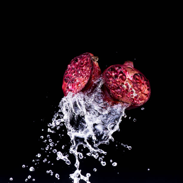 pomegranate in water splash on black backround