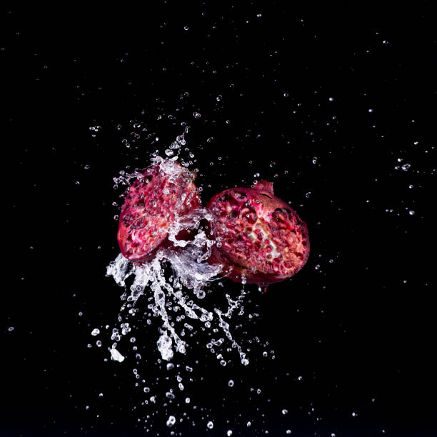 pomegranate in water splash on black backround