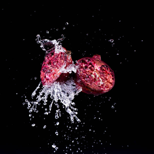 pomegranate in water splash on black backround