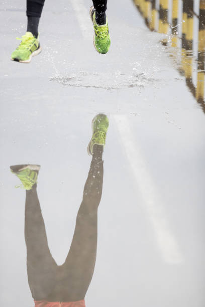 istock Woman jogging through puddles 682148166