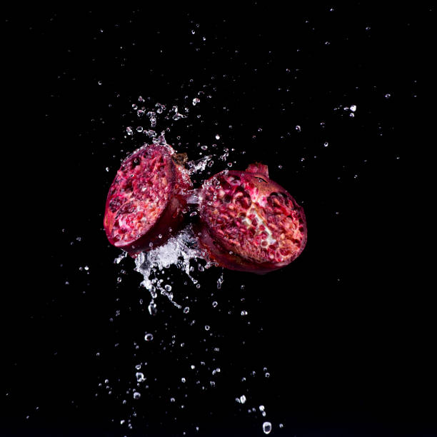 pomegranate in water splash on black backround